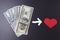 Buy love for money concept. Sell love. Relationships for money. Dollars and red heart on black background.