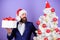 Buy present. Man bearded hipster formal suit near christmas tree. Office christmas party. Winter holidays. Christmas