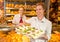 Buyer in bakery presenting tray with sandwiches