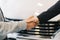 Buyer of car shaking hands with seller in auto dealership, in front of car