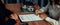 Buyer signs the loan contract paper with a pen on the desk. Enthusiastic