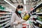 Buyer wearing a protective mask.Shopping during the pandemic quarantine.Nonperishable smart purchased household pantry groceries