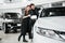 Buying their first car together. High angle view of young car salesman standing at the dealership telling about the