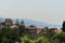 Byblos city skyline with red roof tops of ancient houses and gardens vegetation with the shore and mountain in far end