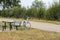 A bycicle parked near a bench and between bushes in park