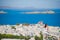 BYoung lady relaxing on the edge of swimming pool with beautiful view of amazing greek village