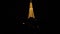 Bypass Gimbal shot around Eiffel tower in Paris at night. Warm glowing huge metal construction