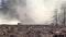 The cab of an agricultural tractor can be seen in the field, the tractor plows the ground behind it is a cloud of dust