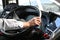 The cab of the public bus driver, one of his hands on the steering wheel, outside the window in the afternoon and sunny. Close-up