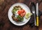 Cabbage fritters with smoked salmon and greek yogurt sauce on a wooden background, top view. Delicious breakfast, tapas,