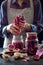 Cabbage kimchi in glass jar. Woman preparing purple cabbage and watermelon radish kimchi. Fermented and vegetarian probiotic food