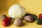 Cabbage, potatoes, cucumbers and tomatoes on yellow background.