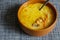 Cabbage soup with mixed sour cream and a metal spoon in a brown earthenware bowl