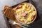 Cabbage stewed with potatoes, sausage, bacon and onions close-up in a bowl. Horizontal top view