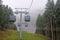 Cabin of Cable car lift arrive to top of the mountain with place of rest, restaurant and hotel in foggy day. Dolomites, Italy.