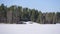 Cabin and cottages at the edge of a frozen lake.