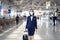 Cabin crew or air hostess wearing face mask walking in airport terminal to the airplanel during the COVID pandemic to prevent coro