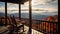 A cabin with a front porch overlooking a mountain vista.