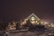 Cabin in the snow between snowcovered pine trees