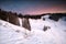 Cabin in snowy mountains at sunrise