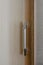 Cabinet handle close-up. A fragment of a wardrobe made of laminated chipboard, furniture fittings. Vertical photo