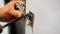 The cabinet maker tightens the adjustment screw on the cabinet door hinge in the kitchen. Installation and adjustment of