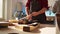 Cabinetmaker in assembly shop lacquering wooden board, close up