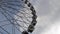 Cabins Ferris Wheel rotating on a cloudy sky background.