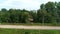 Cabins to carry passengers move towards each other. The dense vegetation is rich green in the background. Country gravel