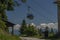 Cable car Kanzelhohe in green needles forest in summer sunny day