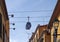 Cable car running directly above the rooftops of a street in the city center of funchal madeira with a blue sky
