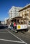 Cable car on top of a San Francisco Hill with bay water in background