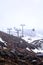 Cable cars and ski lifts going up and down snow blanketed slopes of the mountain while a snow storm building up. Mt