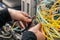 Cable cutters in the hands of an internet connection installer. The specialist removes unnecessary wires in the data center.