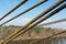 Cables and ropes of a suspension bridge close-up. Fixing the old bridge over the river. Rusty iron cables against a blue sky