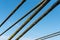 Cables and ropes of a suspension bridge close-up. Fixing the old bridge over the river. Rusty iron cables against a blue sky