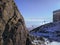 Cableway high in mountains High Tatras, Slovakia, behind a big rock. Rocky mountain snow covered overlooked the clear sky.