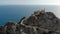 Cabo de Gata old lighthouse located on rocky mountain top. Aerial footage drone point of view beacon surrounded by Mediterranean