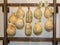 Caciocavallo Italian Cheese Shapes Hung from a Wooden Bar