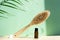 Cactus bristle brush for anti-cellulite massage and massage oil on a green background. The concept of body care. Spa