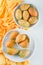 Cactus fruits in  bowl and plates top view on yellow textile and white background