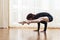 Cacuasian Woman Doing Yoga Tittibhasana Posture Indoors