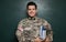 Cadet with books near chalkboard. Military education