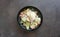 Caesar salad in black bowl on the dark background