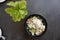 Caesar salad in black bowl on the dark background