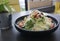 Caesar salad in black bowl on the dark background