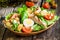 Caesar salad with croutons, quail eggs, cherry tomatoes and grilled chicken in wooden plate