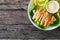 Caesar salad - fried chicken breast and vegetables on wooden table