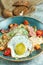 Caesar salad with fried egg. Beautiful serving dishes. Light gray background. Restaurant menu