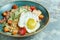 Caesar salad with fried egg. Beautiful serving dishes. Light gray background. Restaurant menu